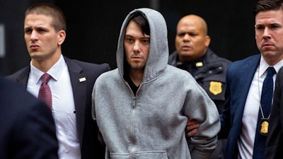 In this Dec. 17, 2015, file photo, Martin Shkreli, center, the former hedge fund manager under fire for buying a pharmaceutical company and ratcheting up the price of a life-saving drug, is escorted by law enforcement agents in New York after being taken into custody following a securities probe. State and federal authorities sued the imprisoned drug entrepreneur Monday, Jan. 27, 2020, over business tactics that helped make him the bad-boy face of profiteering in the pharmaceuticals industry, seeking to bar the so-called 'Pharma Bro' from the industry for life.