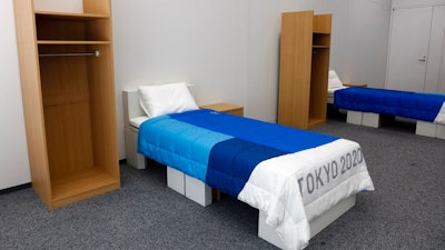 Two sets of bedroom furniture, including cardboard beds, for the Tokyo 2020 Olympic and Paralympic Villages are shown in a display room Thursday, Jan. 9, 2020, in Tokyo. Tokyo Olympic athletes beware - particularly larger ones. The single bed frames in the Athletes Village at this year's Olympics will be made of cardboard. The single bed frames will be recycled into paper products after the games. The mattress components - the mattress are not made of cardboard - will be recycled into plastic products.