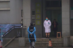 Hospital staff stand outside the emergency entrance of Wuhan Medical Treatment Center, where some infected with a new virus are being treated, in Wuhan, China, Wednesday, Jan. 22, 2020. The number of cases of a new coronavirus from Wuhan has risen to over 400 in China health authorities said Wednesday.