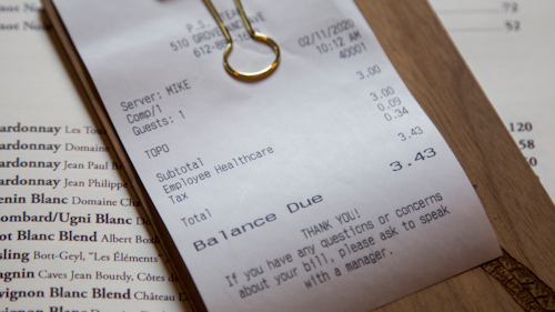 In this Feb. 11 photo, a line item shows an example of how the charge that Brent Frederick, founder of Jester Concepts, a restaurant group in Minneapolis uses as a 3% voluntary surcharge on guest checks to help pay for health insurance and mental health services and says almost all guests agree to pay it.
