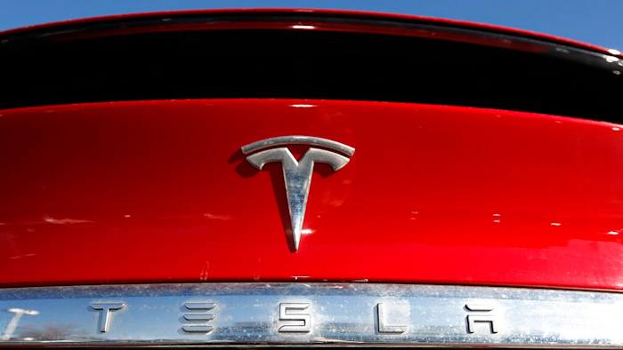 In this Feb. 2, 2020 file photograph, the company logo sits on an unsold 2020 Model X at a Tesla dealership in Littleton, Colo. Shares of Tesla Inc. fell 4% in early trading Thursday, Feb. 13, after the electric vehicle and solar panel maker said it would sell more than $2 billion worth of additional shares. The move comes just two weeks after CEO Elon Musk said the company had enough cash to fund its capital programs and it didn't need to raise any more money.