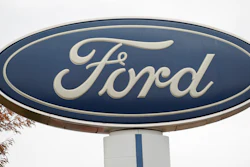 In this Oct. 20, 2019, file photo, the company logo stands over a long row of unsold vehicles at a Ford dealership in Littleton, Colo.