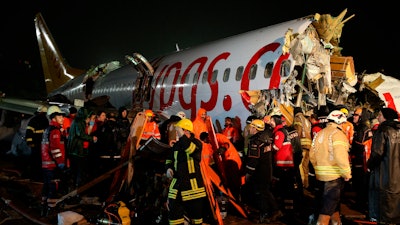 Rescue members evacuate an injured person from the wreckage of a plane after it skidded off the runway at Istanbul's Sabiha Gokcen Airport, in Istanbul, Wednesday, Feb. 5, 2020.