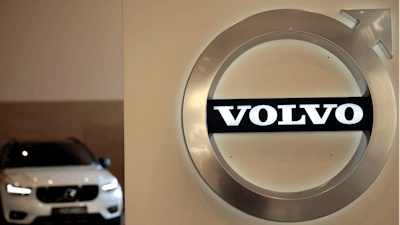 A Volvo car is parked behind the Volvo logo in the lobby of the Volvo corporate headquarters, prior to a media conference on the 2019 Full Year Financial Results, in Brussels, Thursday, Feb. 6, 2020.