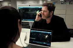 In this Thursday, Feb. 13, 2020 photo, John Brownstein, right, co-founder of HealthMap, a system using artificial intelligence to monitor global disease outbreaks, speaks on a phone in a HealthMap work area at Boston Children's Hospital in Boston.