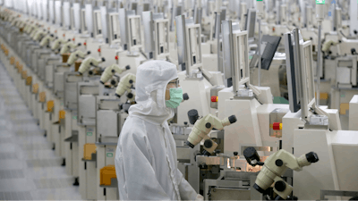 In this Feb. 20 photo, a worker sits at a production line at a microelectronics factory in Nantong in eastern China's Jiangsu Province. China on Friday suspended more punitive tariffs on imports of U.S. industrial goods in response to a truce in its trade war with Washington that threatened global economic growth.
