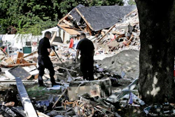 In this Sep. 21, 2018, file photo, fire investigators pause while searching the debris at a home which exploded following a gas line failure in Lawrence, Mass.