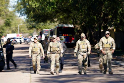 Law enforcement personnel walk along Rockcrest Rd. after an explosion occurred at nearby Watson Grinding and Manufacturing, Friday, Jan. 24, 2020, in Houston.