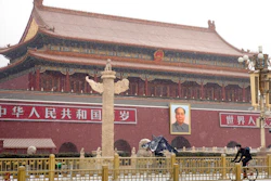 A man wears a face mask as he rides a bicycle past Tiananmen Gate near Tiananmen Square during a snowfall in Beijing, Wednesday, Feb. 5, 2020. Deaths from a new virus rose to 490 in mainland China on Wednesday while new cases on a Japanese cruise ship, in Hong Kong and in other places showed the increasing spread of the outbreak and renewed attention toward containing it.