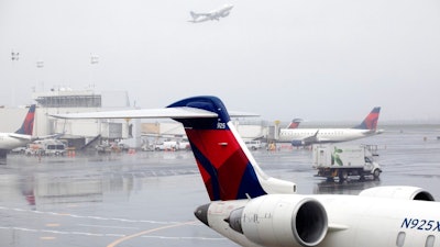 In this Oct. 29, 2019, file photo Delta planes are parked at the new $3.9 billion Terminal C at LaGuardia Airport in New York. Delta Air Lines said Friday, Feb. 14, 2020, that it will invest $1 billion over the next 10 years in measures designed to offset climate-warming carbon emissions from its planes.