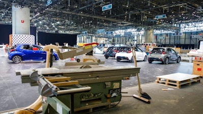 Cars are pictured as workers stop the preparation of the 90th Geneva International Motor Show, GIMS, at Palexpo, in Geneva, Switzerland, Friday, Feb. 28, 2020. The 90th edition of the International Motor Show, scheduled to begin on March 5th, is cancelled due to the advancement of the (Covid-19) coronavirus in Switzerland. The Swiss confederation announced today that all events involving more than 1,000 people would be banned until 15 March.