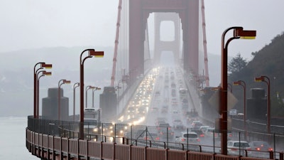 In this Jan. 5, 2016, file photo, traffic crosses the Golden Gate Bridge in the rain in this view from Sausalito, Calif. The Trump administration has ended its antitrust probe into a deal between California and four big automakers, after failing to find that the companies' conduct violated the law.