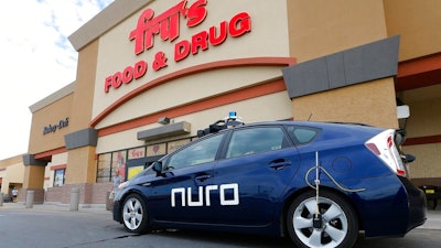 In this Aug. 16, 2018 file photo, a self-driving Nuro vehicle parks outside a Fry's supermarket in Scottsdale, Ariz. For the first time, the U.S. government's highway safety agency has approved a Nuro's request to deploy a self-driving vehicle that doesn't meet federal safety standards for human-driven cars and trucks. The National Highway Traffic Safety Administration granted temporary approval for the Silicon Valley robotics company to run a low-speed autonomous delivery vehicle without side and rear-view mirrors used by human drivers.