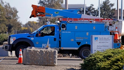 In this Feb. 11, 2020, file photo a Pacific Gas & Electric truck leaves the company's Oakland Service Center in Oakland, Calif. Pacific Gas and Electric said Tuesday, Feb. 18, that it expects to become more profitable than ever after it emerges from bankruptcy and pays off more than $25 billion in losses sustained in catastrophic wildfires ignited by its outdated equipment.