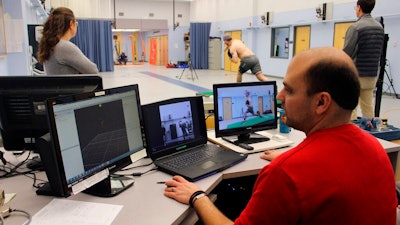Research engineer Matthew Solomito analyzes data as Central Connecticut pitcher Michael DeLease throws off a smart mound at the Center for Motion Analysis in Farmington, Conn. on Tuesday, Jan. 28, 2020. The new technology allows scientists to better study pitching mechanics to enhance efficiency and prevent injuries.