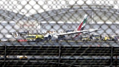 In this Aug 3, 2016 file photo, a damaged Boeing 777 is seen at the Dubai airport after it crash-landed, in Dubai, United Arab Emirates. An investigative report released Thursday, Feb. 6, 2020, found that the pilots of an Emirates flight that crashed in 2016 and caught fire in Dubai failed to realize the engines of their Boeing 777 remained idle as they tried to take off from a failed landing attempt.