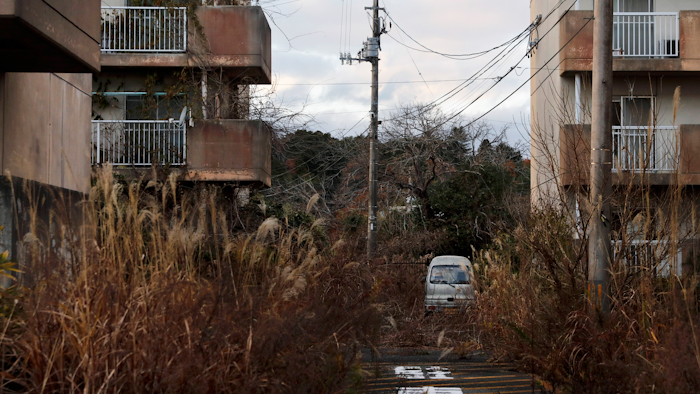 In this Dec. 3, 2019, file photo, weeds grow in an abandoned apartment complex, in Futaba, Fukushima prefecture, Japan.