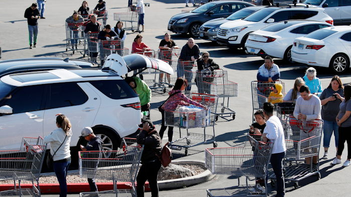 A line of people waiting to buy supplies amid coronavirus fears snakes through a parking lot at a Costco, Saturday, March 14, 2020, in Las Vegas.