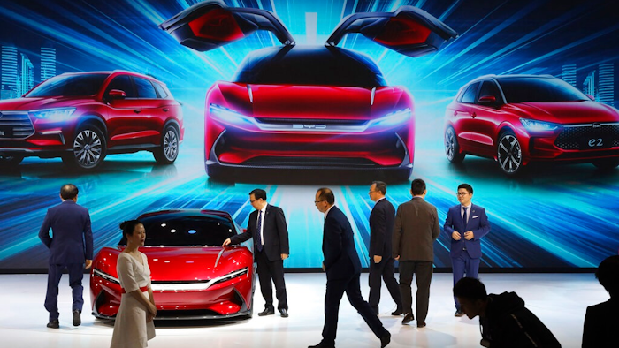 In this April 16, 2019, file photo, attendees take a close look at cars from BYD at the Auto Shanghai 2019 show in Shanghai. China’s auto sales plunged 81.7% in February, 2020, from a year ago after Beijing shut down much of the economy to fight a virus outbreak, adding to problems for an industry that already was struggling with shrinking demand.