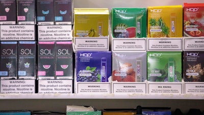 This Jan. 31, 2020 photo shows various brands and flavors of disposable vape devices at a store in the Brooklyn borough of New York. On Thursday, Feb. 6, 2020, the U.S. government began enforcing restrictions on flavored electronic cigarettes aimed at curbing underage vaping.