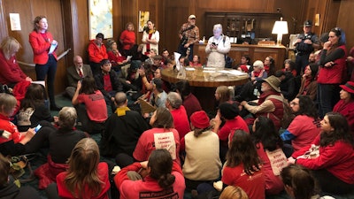 In this Nov. 21, 2019, file photo, demonstrators against a proposed liquid-natural gas pipeline and export terminal in Oregon sit in in the governor's office in the State Capitol in Salem, Ore., to demand Democratic Gov. Kate Brown stand against the proposal.