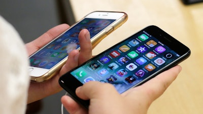 In this Sept. 16, 2016 file photo, a customer compares her iPhone 6, left, with an iPhone 7 at an Apple Store in Chicago.