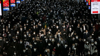 A large crowd wearing masks commutes through Shinagawa Station in Tokyo on Tuesday, March 3. The Japanese government has indicated it sees the next couple of weeks as crucial to containing the spread of COVID-19, which began in China late last year.