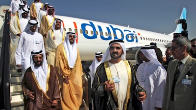 In this Nov. 15, 2009 file photo, Sheikh Mohammed bin Rashid Al Maktoum, Vice President and Prime Minister of the United Arab Emirates and ruler of Dubai, 3rd right, visits a FlyDubai aircraft at the Dubai Airshow in Dubai, United Arab Emirates.