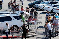 A line of people waiting to buy supplies amid coronavirus fears snakes through a parking lot at a Costco, Saturday, March 14, 2020, in Las Vegas.