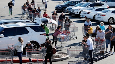 A line of people waiting to buy supplies amid coronavirus fears snakes through a parking lot at a Costco, Saturday, March 14, 2020, in Las Vegas.