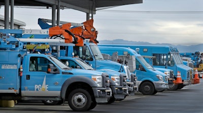 In this Jan. 14, 2019, file photo, Pacific Gas & Electric vehicles are parked at the PG&E Oakland Service Center in Oakland, Calif.