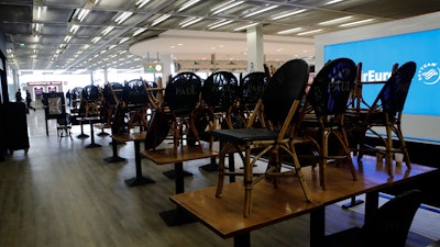 Chairs pile up at cafe at Orly airport Tuesday, March 17, 2020, south of Paris.