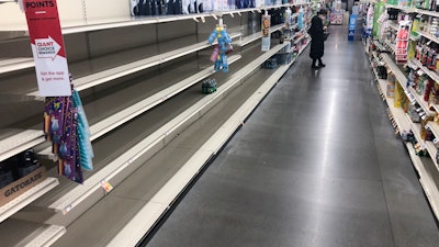 A shopper looks at items near empty shelves at a grocery store in Warrington, Pa., Tuesday, March 17, 2020. Coronavirus concerns have led to consumer panic buying of grocery staples.