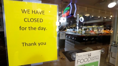 A sign advises of the closure of a restaurant at Pike Place Market on Tuesday, March 17, 2020, in Seattle. Many shops in the landmark market continue to remain open, though business has dropped considerably in recent weeks.