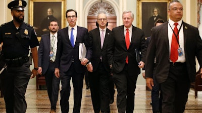 Treasury Secretary Steven Mnuchin, left, accompanied by White House Legislative Affairs Director Eric Ueland and acting White House chief of staff Mark Meadows, walks to the offices of Senate Majority Leader Mitch McConnell on Capitol Hill in Washington on Tuesday, March 24.