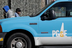 In this photo taken Feb. 18, 2020, people walk behind a Pacific Gas and Electric truck parked in San Francisco.