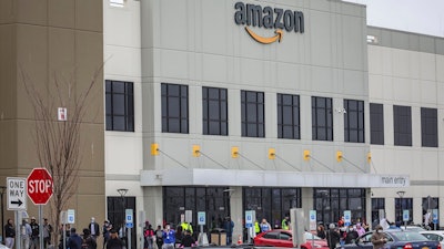 In this March 30, 2020 file photo, workers at Amazon's fulfillment center in Staten Island, N.Y., gather outside to protest work conditions in the company's warehouse in New York.