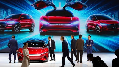 In this April 16, 2019, file photo, attendees take a close look at cars from BYD at the Auto Shanghai 2019 show in Shanghai. China’s auto sales plunged 81.7% in February, 2020, from a year ago after Beijing shut down much of the economy to fight a virus outbreak, adding to problems for an industry that already was struggling with shrinking demand.