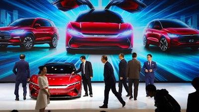 In this April 16, 2019, file photo, attendees take a close look at cars from BYD at the Auto Shanghai 2019 show in Shanghai. China’s auto sales plunged 81.7% in February, 2020, from a year ago after Beijing shut down much of the economy to fight a virus outbreak, adding to problems for an industry that already was struggling with shrinking demand.
