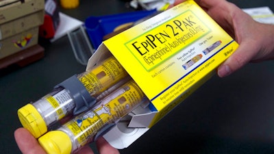 In this July 8, 2016, file photo, a pharmacist holds a package of EpiPens epinephrine auto-injector, a Mylan product, in Sacramento, Calif. On Tuesday, March 24, 2020, the U.S. Food and Drug Administration warned the public about malfunctions involving some EpiPens, the emergency injectors for severe allergic reactions.