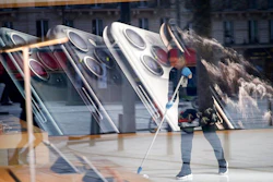 In this March 15, 2020 file photo, a worker cleans the Apple Store on the Champs-Elysees avenue in Paris. French regulators fined Apple 1.1 billion euros ($1.2 billion) on Monday March 16, 2020 for striking deals to keep prices high, in the biggest-ever such sanction by France's Competition Authority.