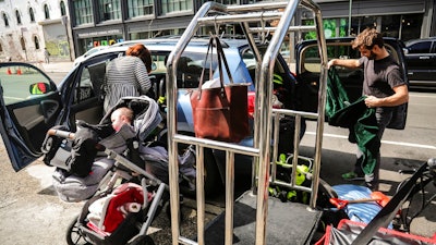 Cailin Sandvig, left, and Justin Bracken, load their family car as they prepare to leave their home in the Crown Heights area of Brooklyn, in New York, with their newborn twins, Milo, center, and Aurelia, 10 months, to avoid the spread of the new coronavirus, Monday, March, 16, 2020. 'We are fleeing the city,' said Sandvig who works remotely for her job. 'We are going to end up in Wheaton, Illinois, where we have a big, old house to be in with my mom that's otherwise empty.'