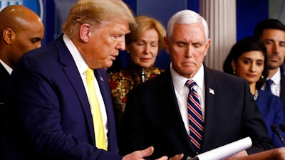 President Donald Trump gestures for Vice President Mike Pence to speaks in the briefing room of the White House in Washington, Monday, March 9, 2020, about the coronavirus outbreak.