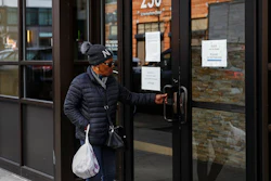 Visitors are unable to gain access to the Department of Labor due to closures over coronavirus concerns, Wednesday, March 18, 2020, in New York. Applications for jobless benefits are surging in some states as coronavirus concerns shake the U.S. economy. The sharp increase comes as governments have ordered millions of workers, students and shoppers to stay home as a precaution against spreading the virus that causes the COVID-19 disease.