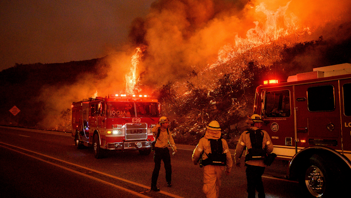In this Nov. 26, 2019, file photo, firefighters battle the Cave Fire as it flares up along Highway 154 in the Los Padres National Forest above Santa Barbara, Calif.