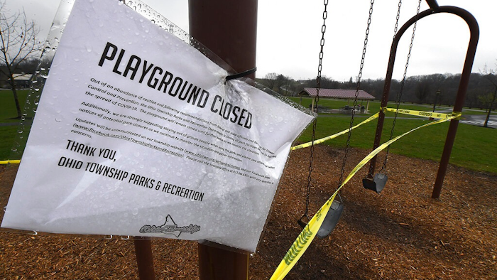 A sign announces another playground closed due to coronavirus concerns as caution tape is wrapped around the swings at Ohio Township Community Park, Tuesday, April 7, 2020, in Ohio Township, Pa.