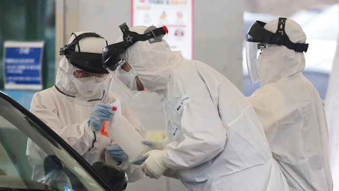 In this March 1, 2020 file photo, medical staff wearing protective suits take samples from a person with suspected symptoms of the new coronavirus at a drive-thru virus test facility in Goyang, South Korea. When the first cases of the disease showed up in South Korea, they reacted quickly with the use of widespread testing, technology to trace at-risk groups, and strict social quarantines and distancing.