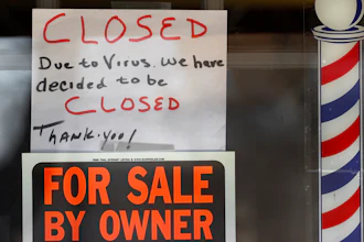 'For Sale By Owner' and 'Closed Due to Virus' signs are displayed in the window of Images On Mack in Grosse Pointe Woods, Mich., Thursday, April 2, 2020.