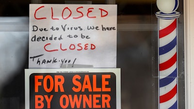 'For Sale By Owner' and 'Closed Due to Virus' signs are displayed in the window of Images On Mack in Grosse Pointe Woods, Mich., Thursday, April 2, 2020.