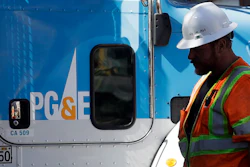In this Aug. 15, 2019, file photo, a Pacific Gas & Electric worker walks in front of a truck in San Francisco.